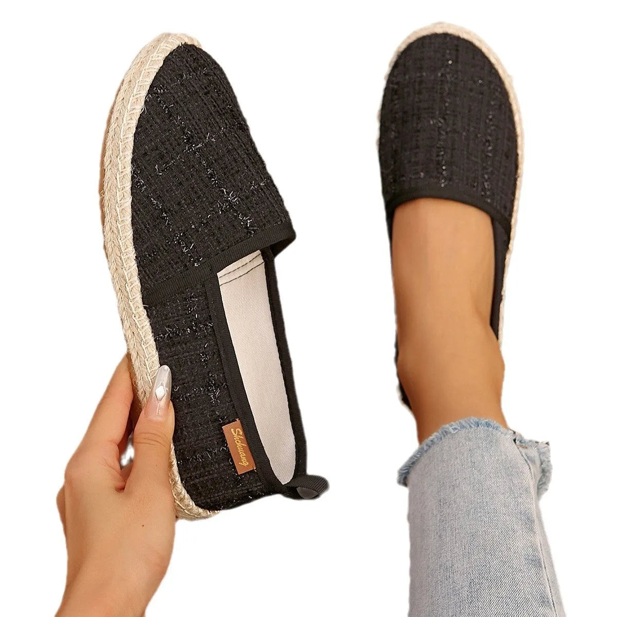 Casual beige canvas fisherman shoes with a textured rope sole on a wooden floor.