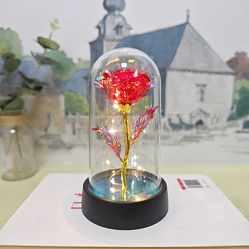 Small decorative night lamp with plastic flowers and a glass-style cover on a black base.