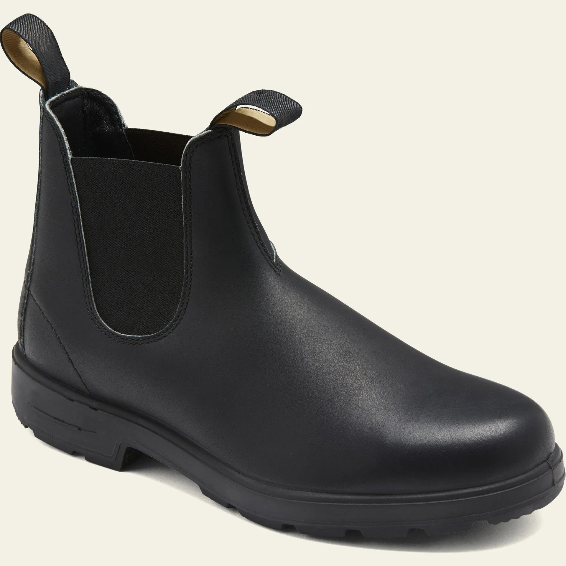 A pair of vintage-style brown Chelsea boots with a round toe and low heel on a wooden floor.