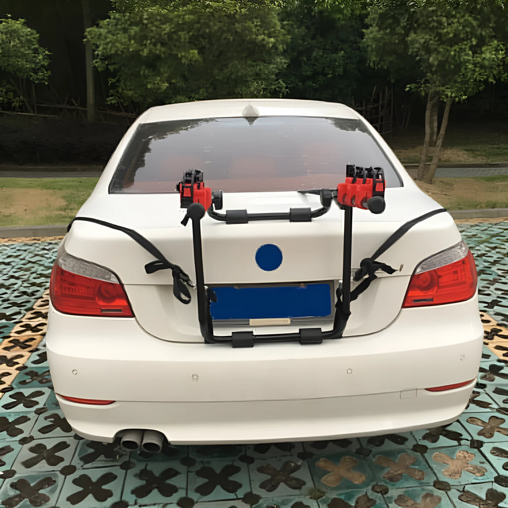 Black and red trunk-mounted car bicycle rack with adjustable straps and foam padding.