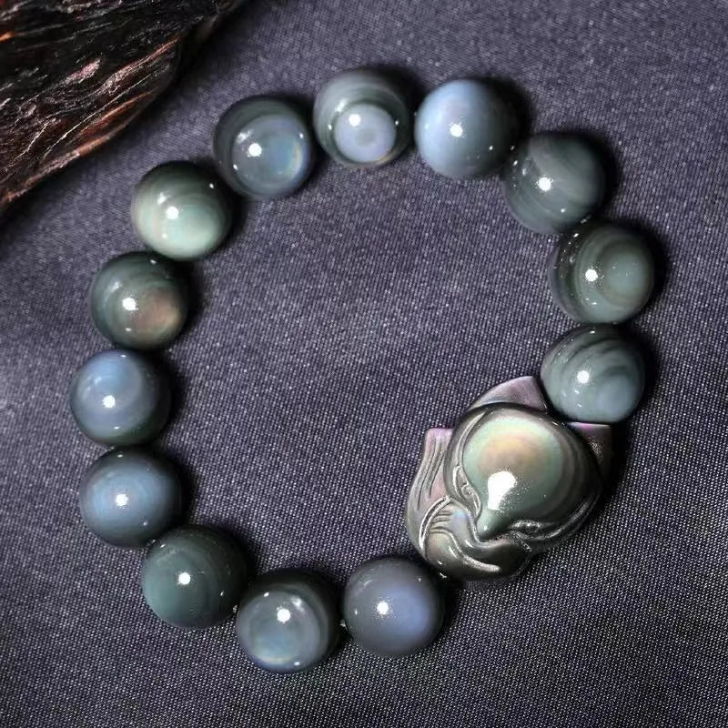 Obsidian fox carved bracelet in cartoon animal style showing detailed carving on black stone surface