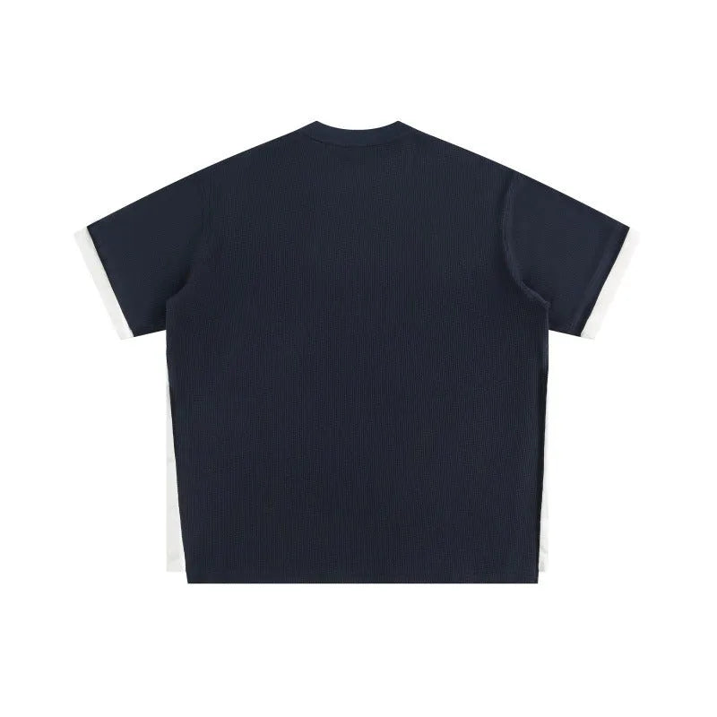 Loose grey waffle-texture T-shirt with embroidered retro alphabet design on the front.