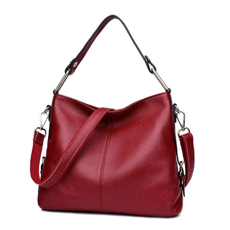 Genuine leather vertical square crossbody bag in black with sewing line detail and external pocket.