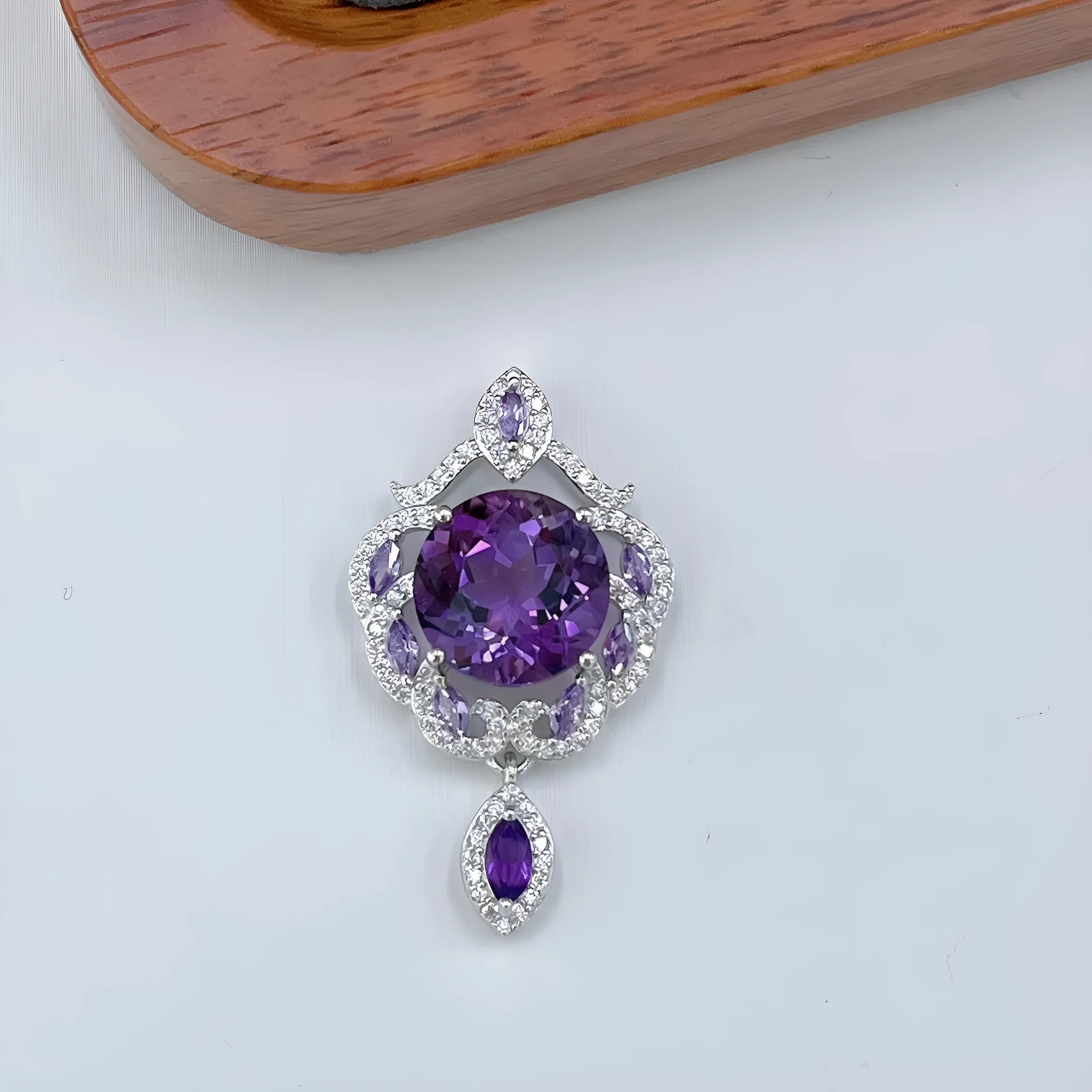 Close-up of a purple amethyst gemstone set in a U-shaped platinum-plated S925 silver pendant with meteor shower detailing.
