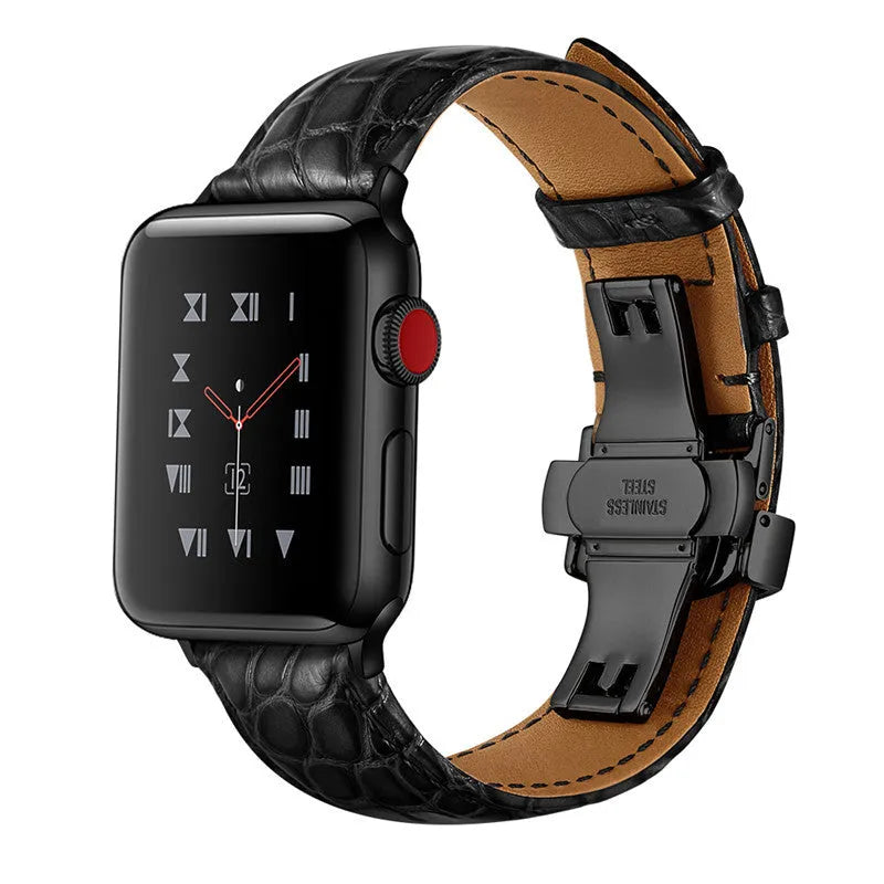 Genuine crocodile skin watch strap in brown with rose gold buckle, 42-44mm width, on a wooden surface