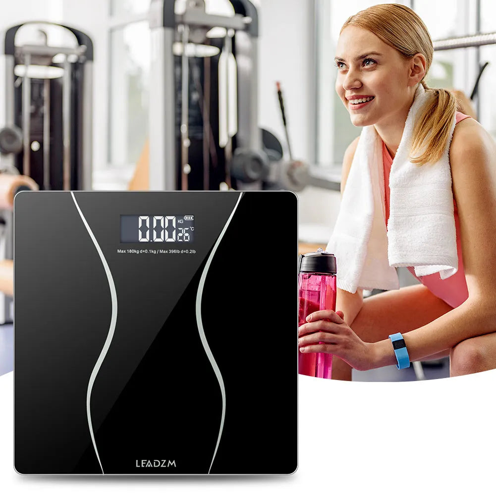 Black electronic digital bathroom scale with a 180kg capacity on a tiled floor.