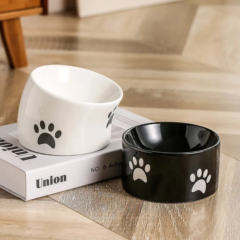 Ceramic cat bowl with cat paw design in black, showing oblique mouth style.