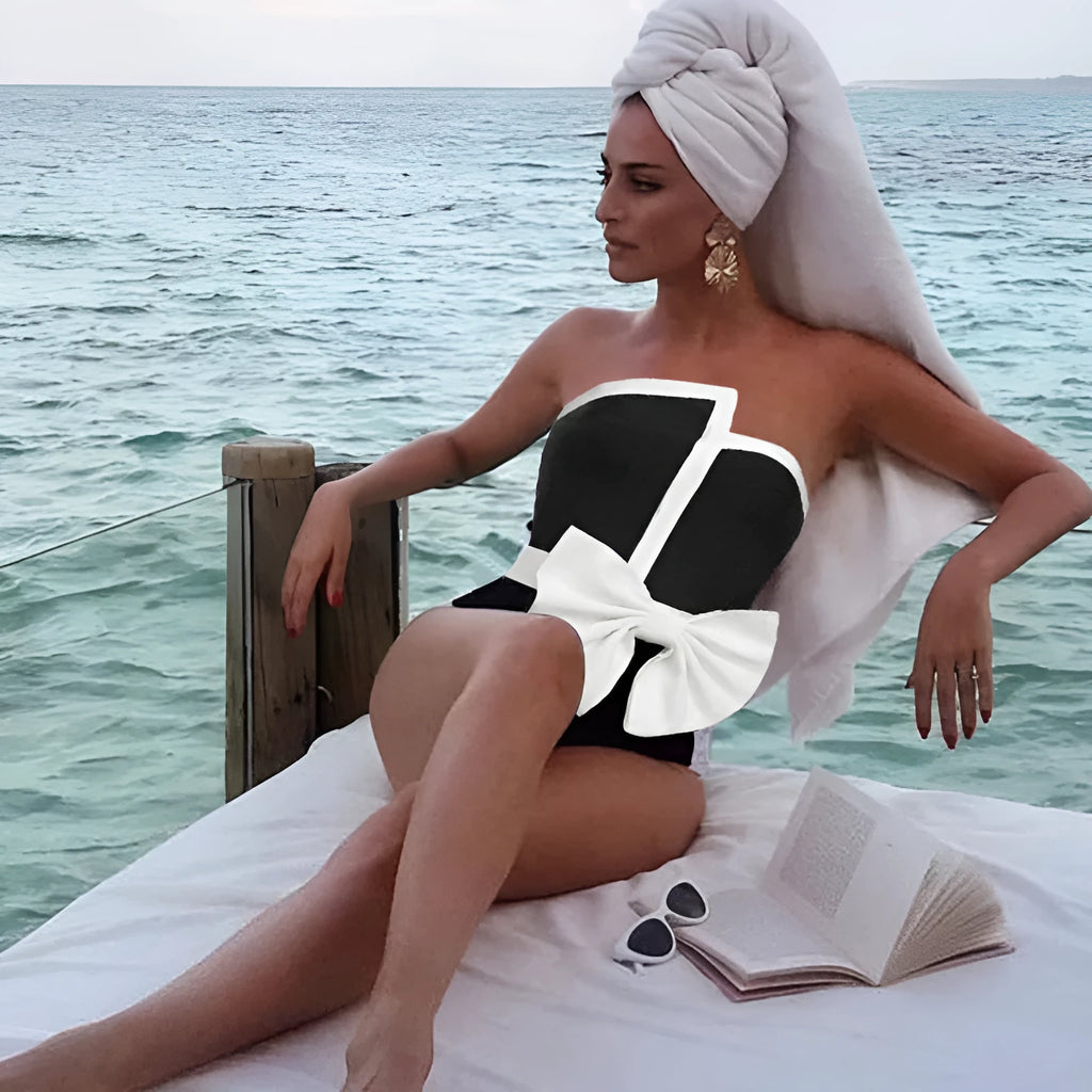 Black and white colour-block women's one-piece swimsuit with an asymmetrical bow on the tube top.