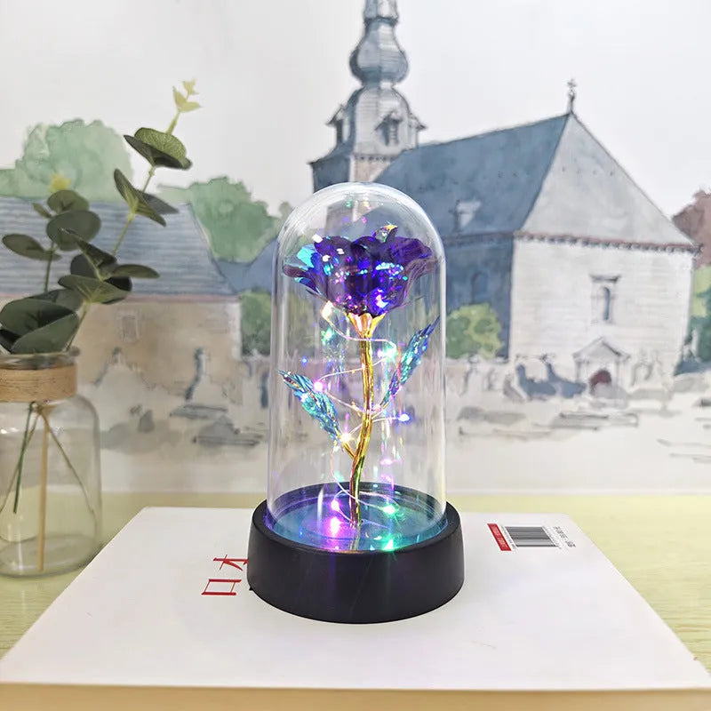 Small decorative night lamp with plastic flowers and a glass-style cover on a black base.