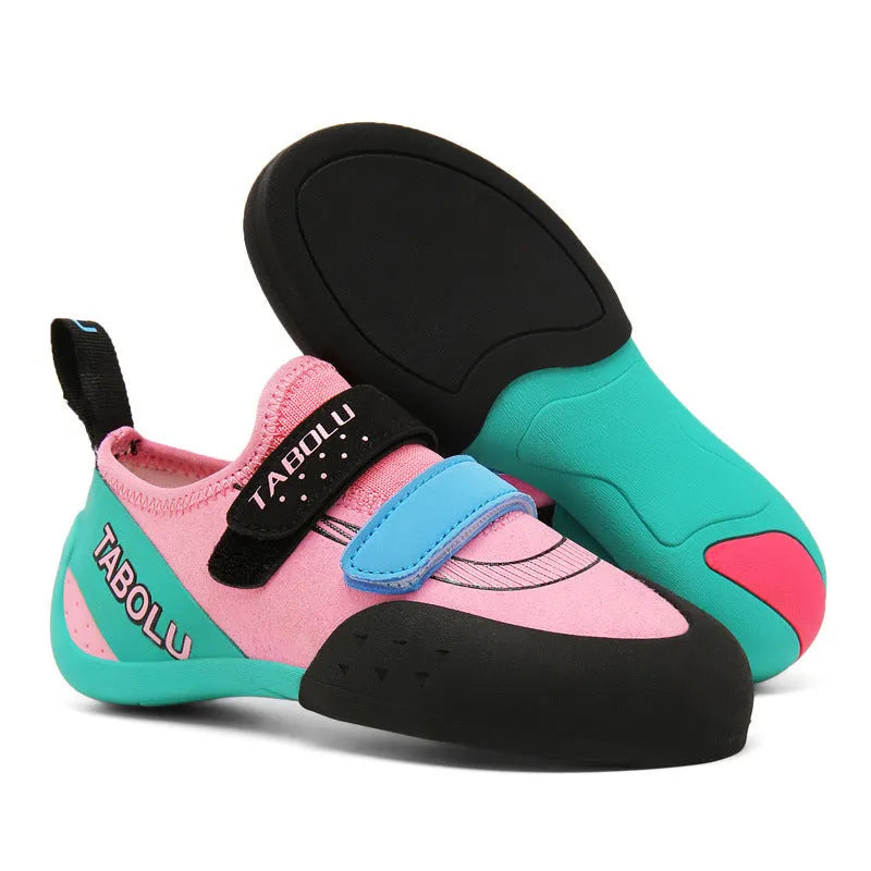 A pair of beginner rock climbing shoes with velcro straps in a black and red colour combination.