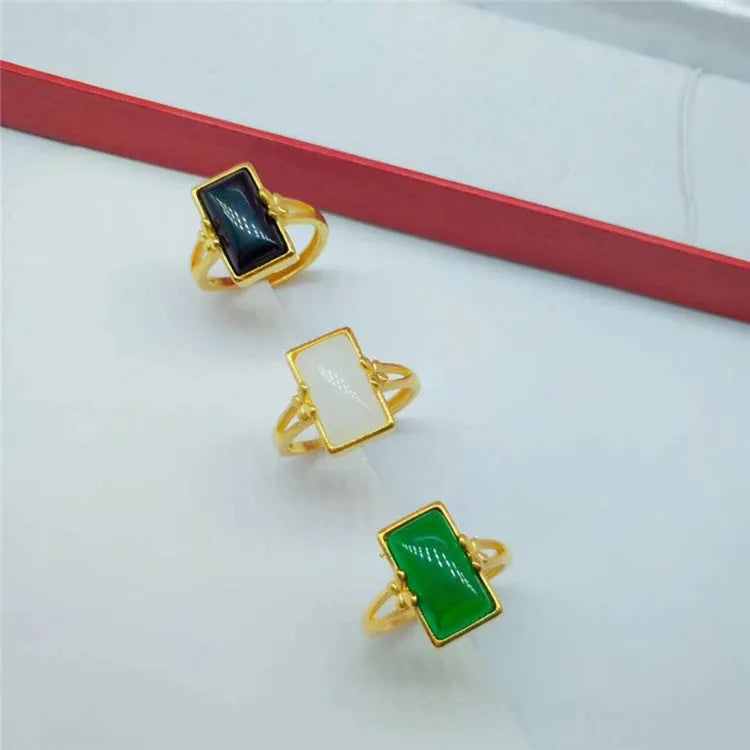 Gold-plated brass ring with an adjustable band and a central green gemstone in a national style.