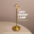 Modern UFO-shaped metal table lamp in grey on a wooden desk, showing touch controls and sleek design.