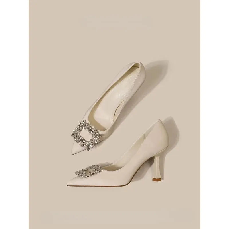Women's creamy-white pointed-toe stiletto high heels on a plain background.