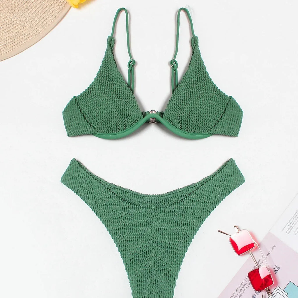 Women's solid green bikini suit with ruffle trim and split leg briefs on a mannequin.