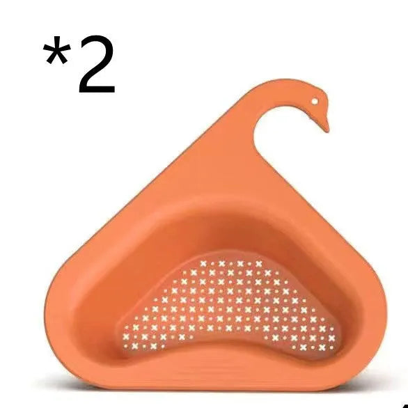 Blue plastic swan-shaped basket hanging over a kitchen sink edge to drain fruit and vegetables.