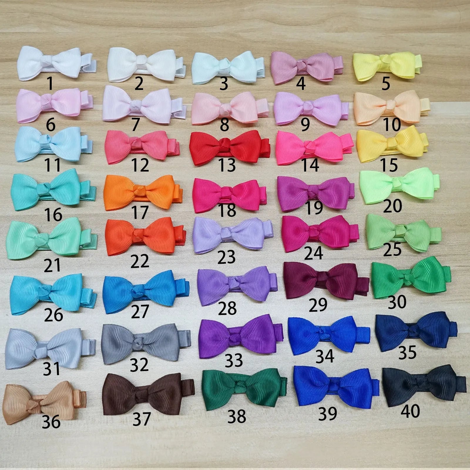 Pastel coloured baby hair clips and bows arranged by colour with non-slip lined interiors visible