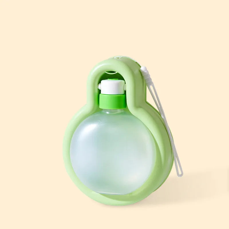 Green portable dog water bottle with pull-out drinking bowl, shown next to a dog.
