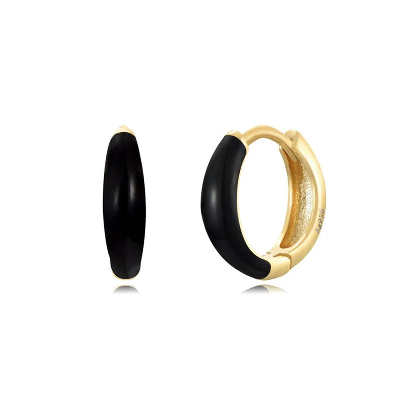 A pair of oval-shaped epoxy resin earrings on a U-shaped curved silver hook, showing a marbled colour finish.