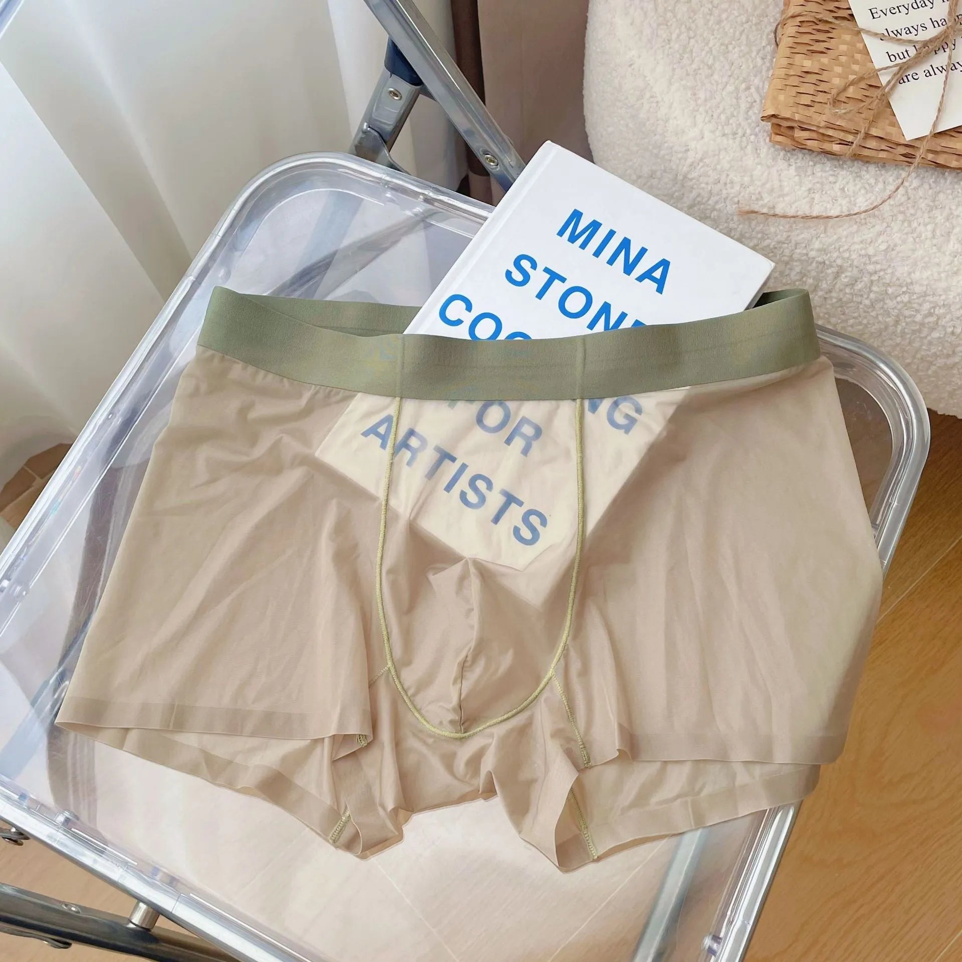 Man wearing thin grey seamless nylon boxer shorts with a mid-waist design.
