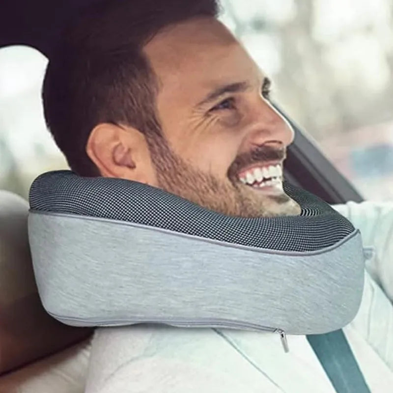 Navy blue U-shaped travel neck pillow rolled up next to its carry bag