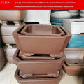 Set of two square stump purple sand flowerpots in brown finish on a flat surface