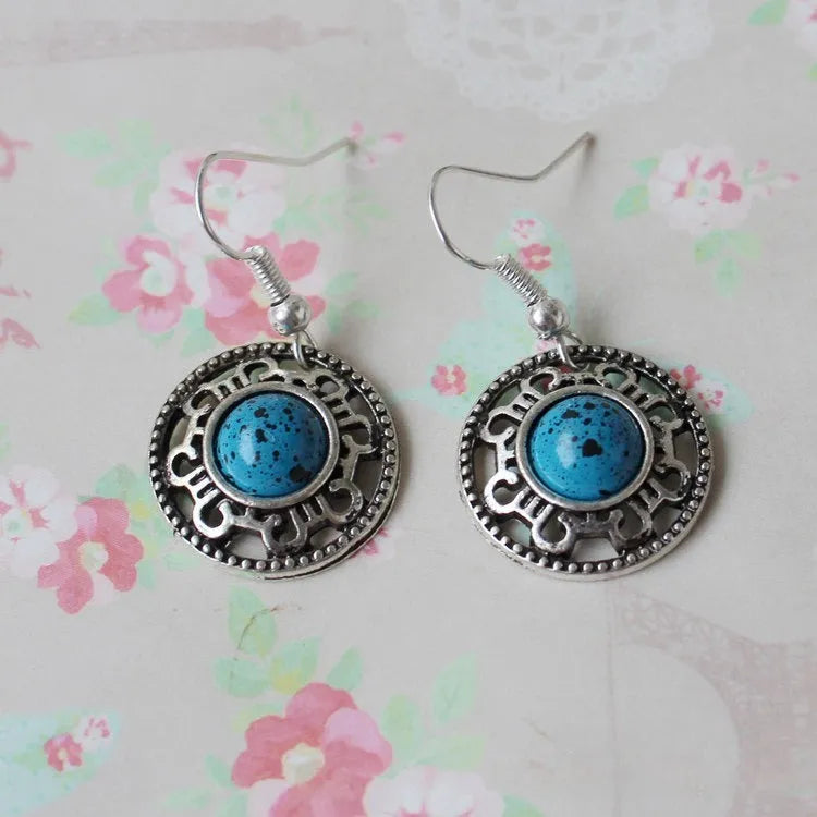 Handmade Miao silver geometric flower disk earrings with turquoise stone in black, blue, or red.