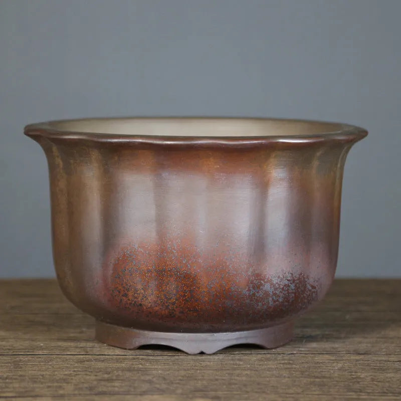 Antique carved wood burning finish on a purple sand ceramic bonsai flowerpot.