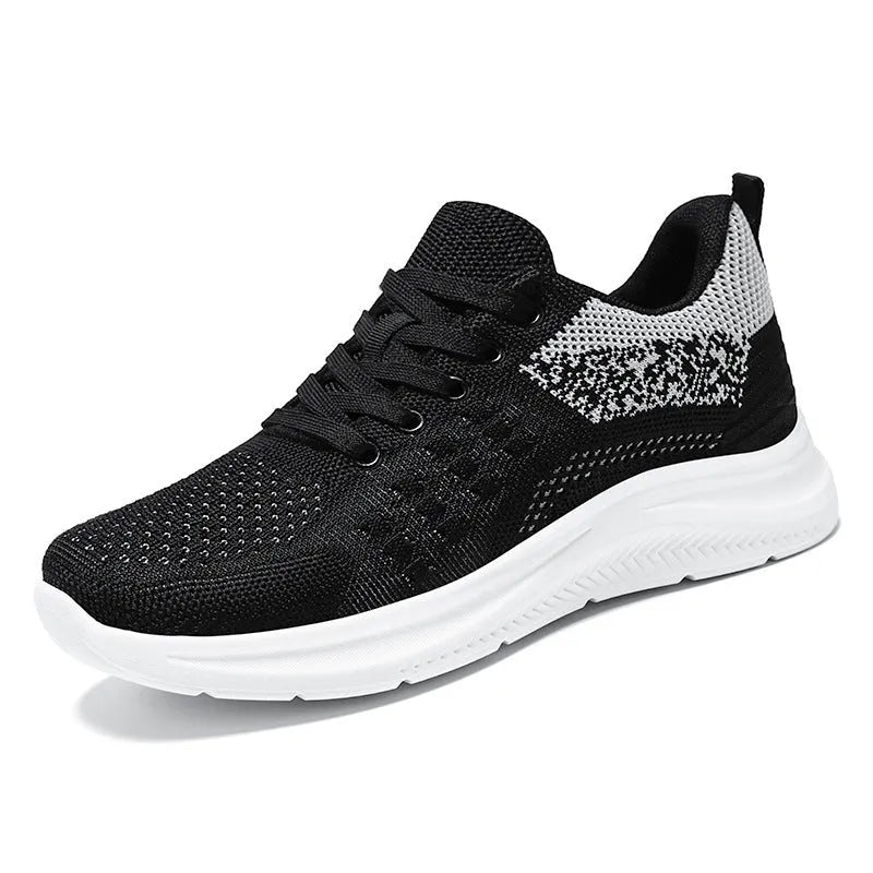 Women's low-top lace-up sneakers in black mesh with a round toe and soft PVC sole.