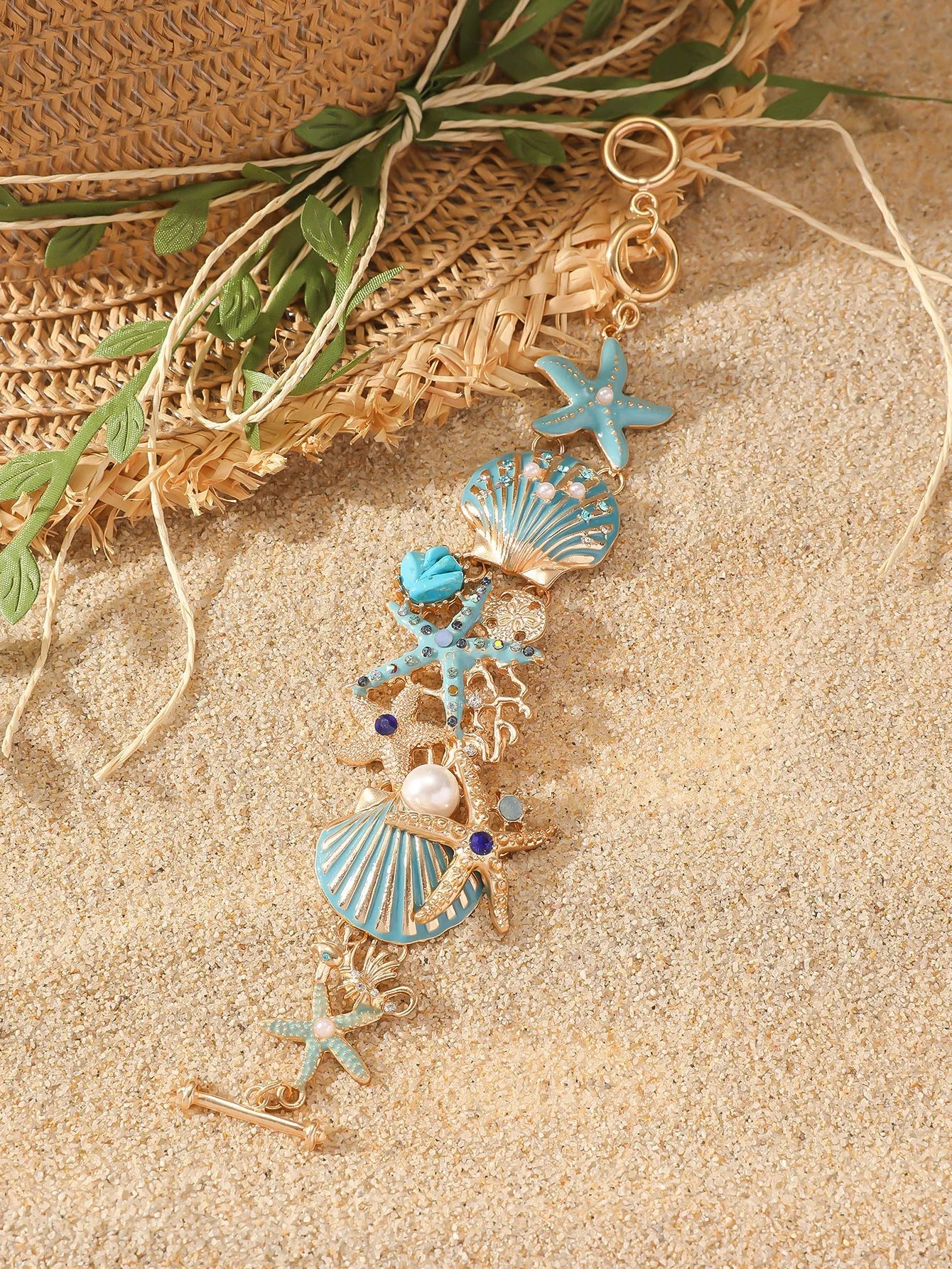 Alloy rhinestone bracelet with boat anchor, shell, and starfish charms in turquoise, red, or blue.
