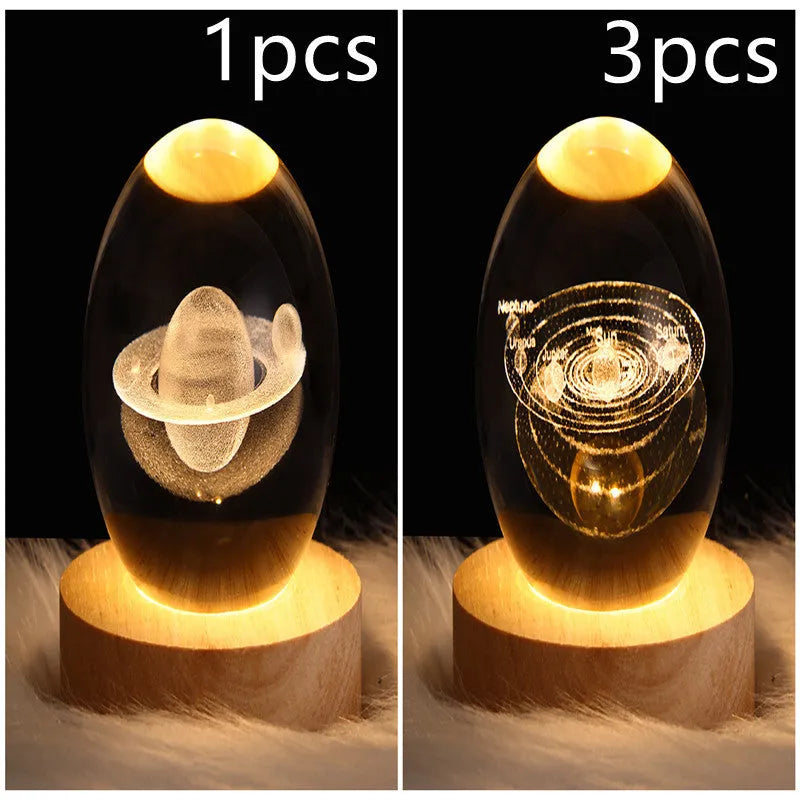 Clear crystal ball LED night light showing a 3D galaxy or planet design, lit from within on a table.