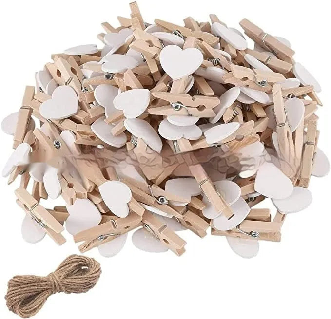 Set of five colourful handmade wooden heart-shaped clips in red, pink, white, and yellow on a wooden surface.
