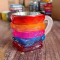 A painted synthetic resin decorative coffee cup in a library or pattern design, measuring 13cm tall.