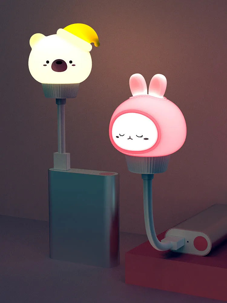 White USB cartoon animal night light in bear design with remote control on wooden table.
