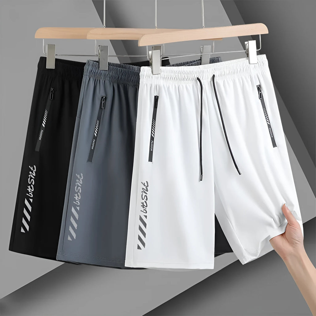 Men's black loose-fit quick-dry nylon sports shorts on a grey background.
