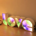 Rainbow style plastic LOVE LED decorative light on a surface.