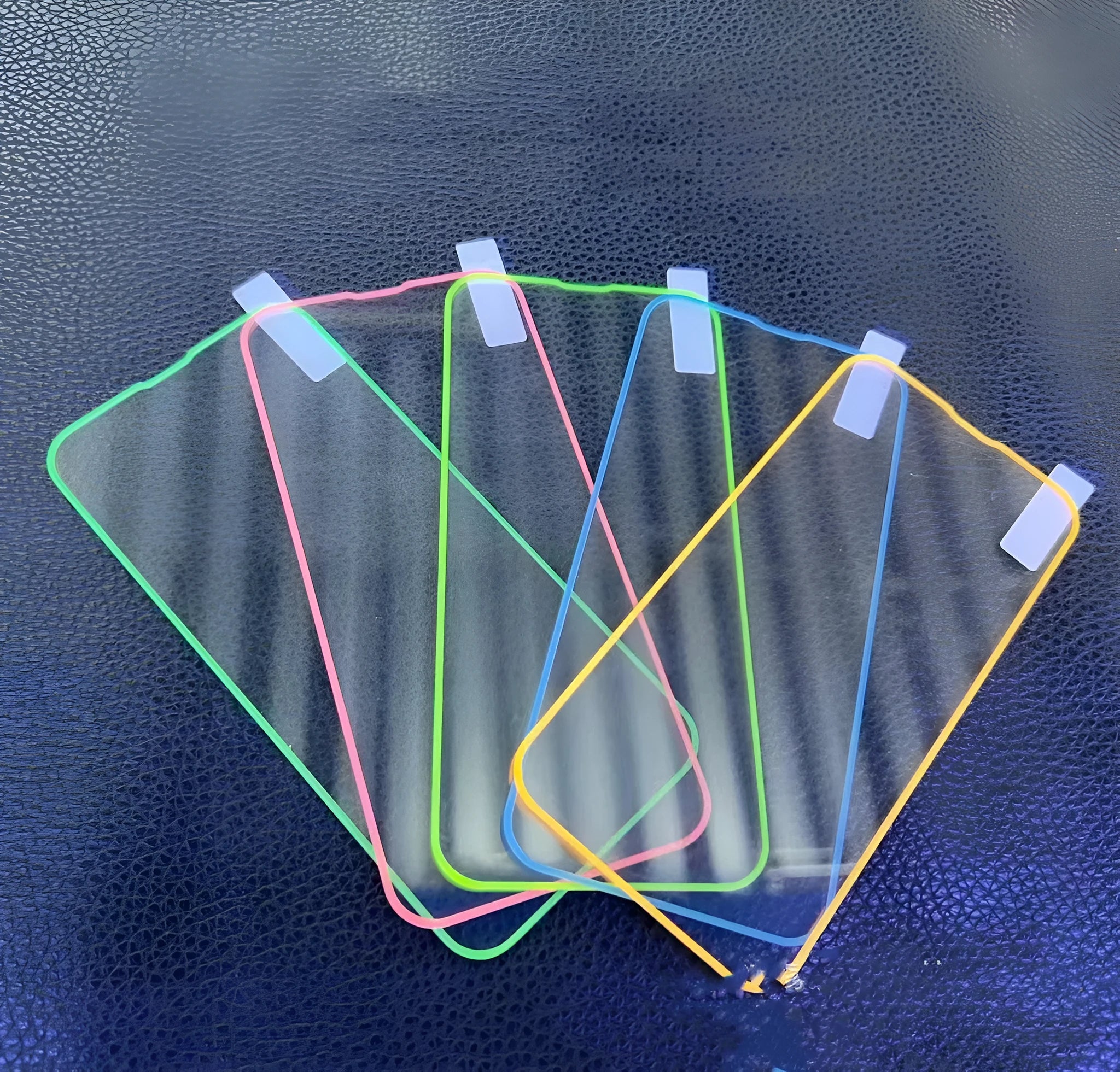 Fluorescent tempered glass screen protector for iPhone with glowing green edge on a phone