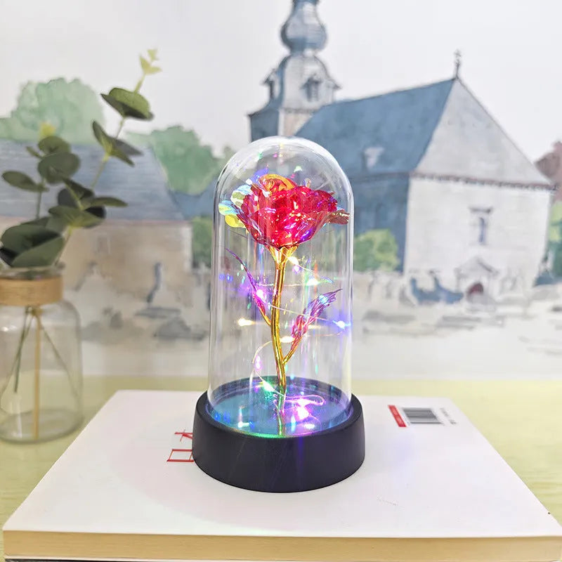 Small decorative night lamp with plastic flowers and a glass-style cover on a black base.