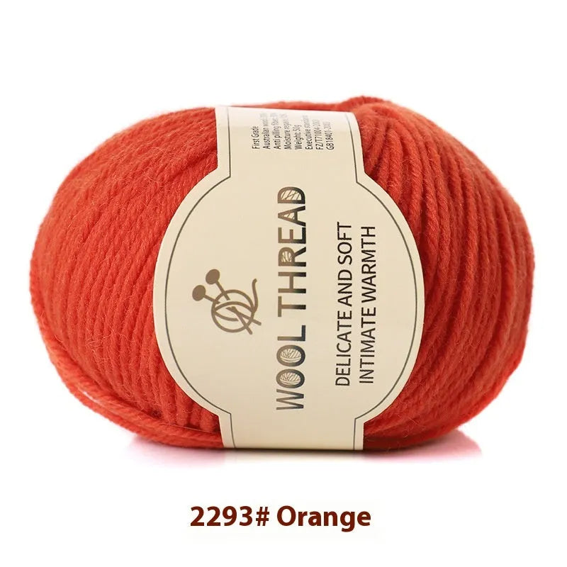 One roll of beige domestic wool hand-knitting yarn for size 10 needles next to knitting needles.