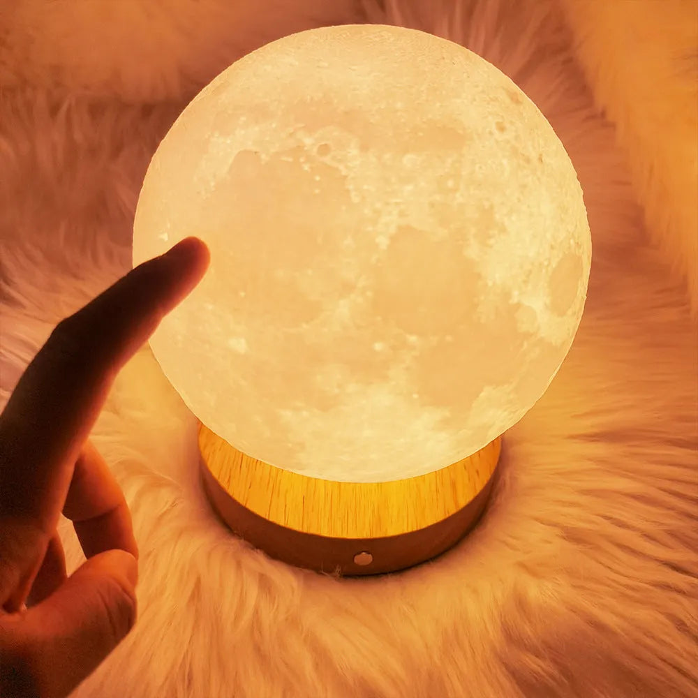 Rotating sleeping moon night lamp with wooden base showing three colour settings