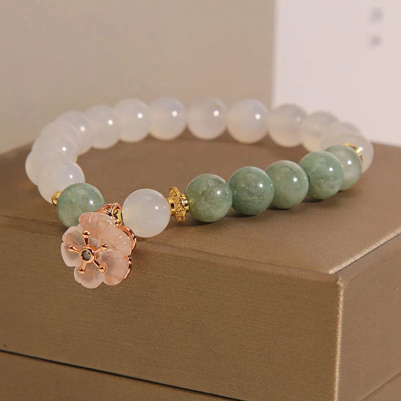 White agate jade bracelet with floral shape on a casual model wrist.