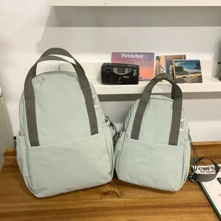 Solid colour nylon backpack with curved shoulder straps shown in five colour options