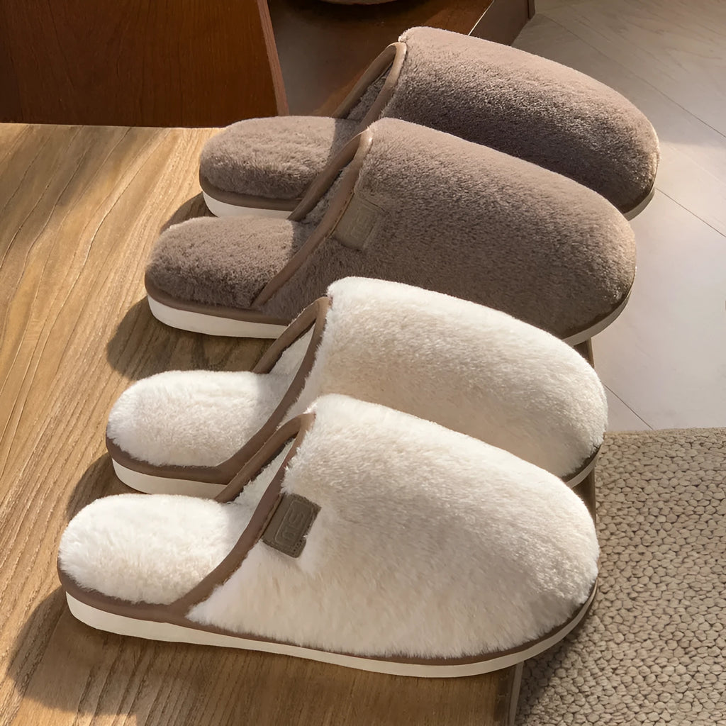 Pair of solid-colour plush winter slippers with a slip-on design and a textured PVC sole.
