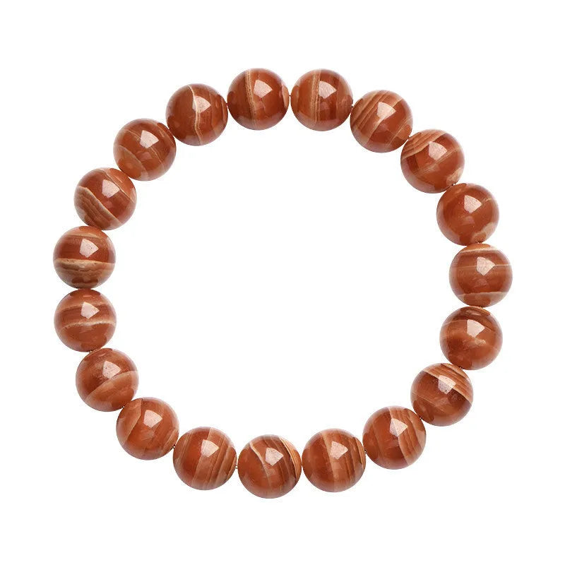 Natural Old Mine Rhodochrosite round bead bracelet with geometric design on wrist.