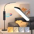 Simple modern LED floor lamp with remote control in white finish on wooden desk for reading