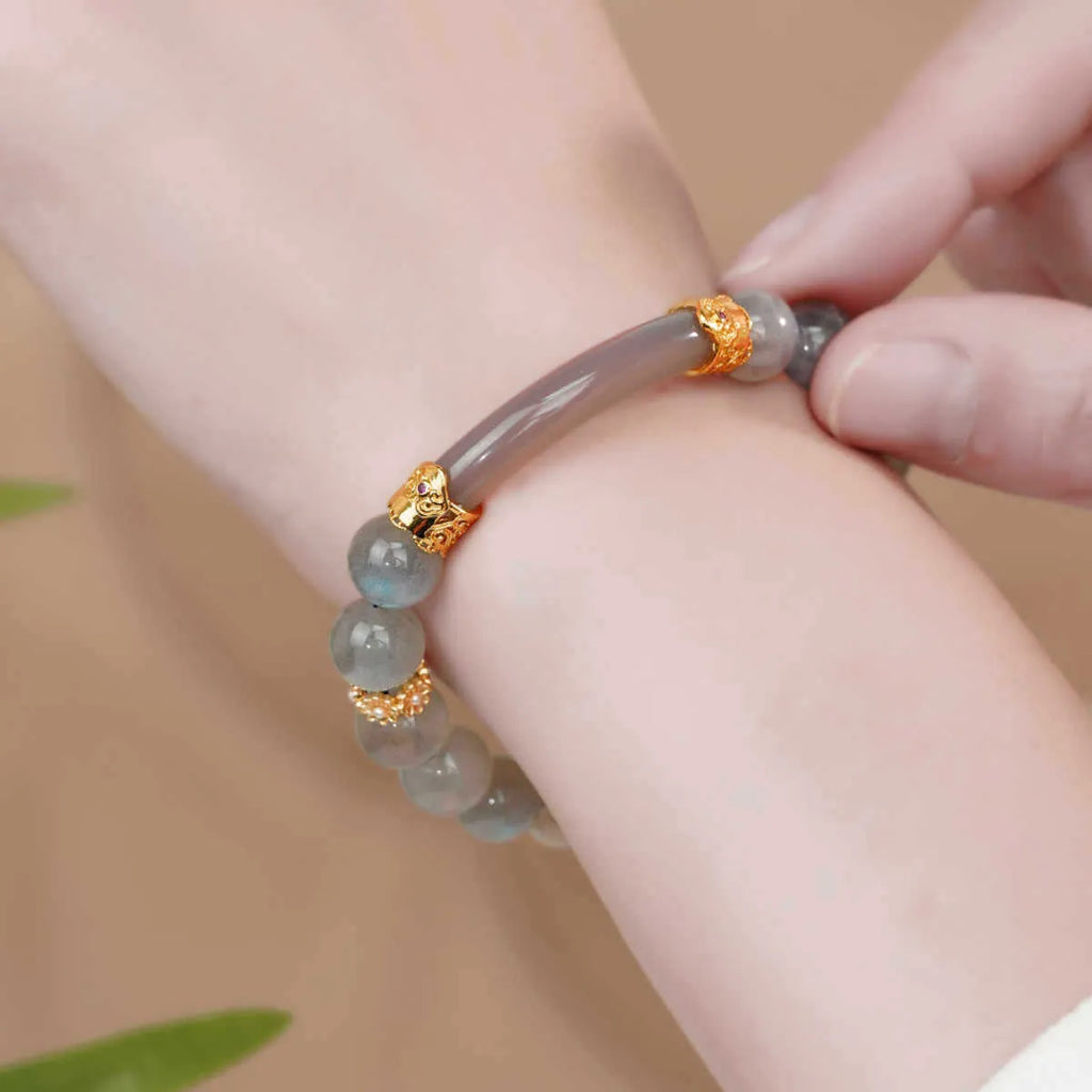 A simple gray moonstone bracelet for women with 8mm round beads on a white background.