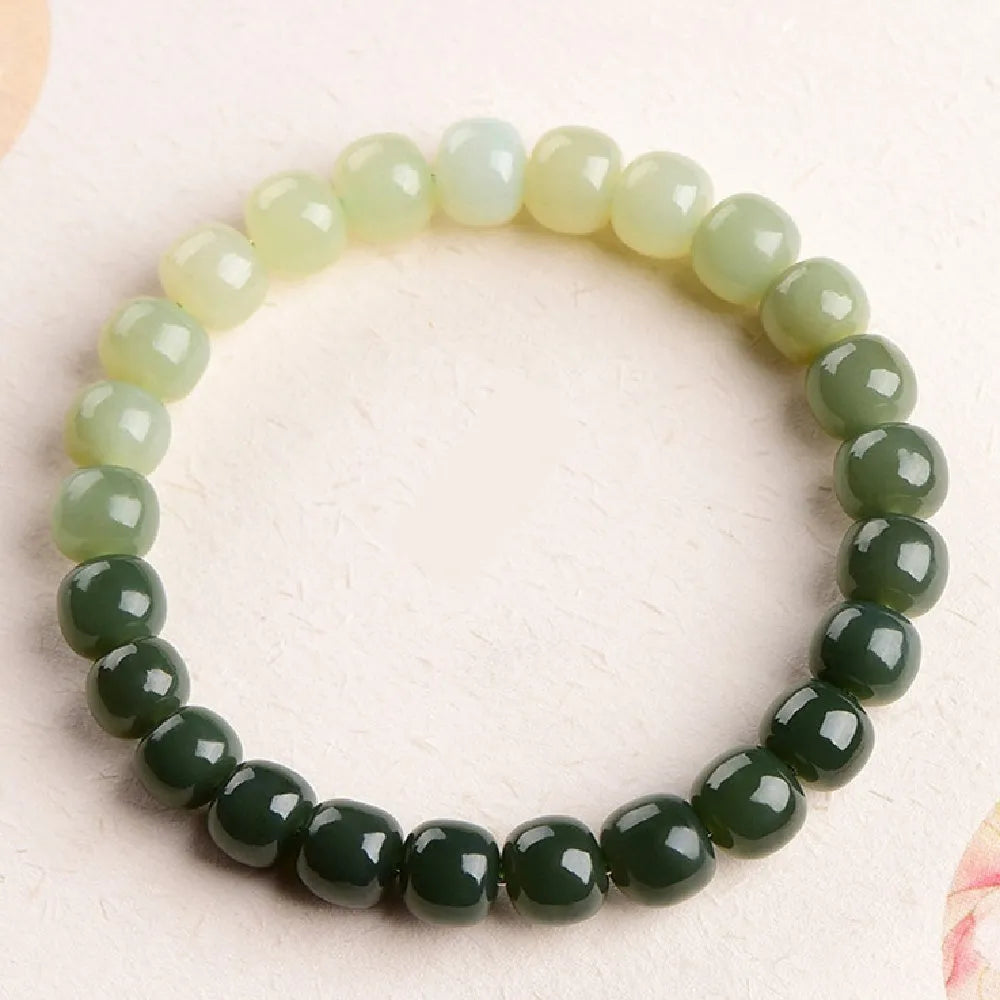 Natural Hetian jade bracelet with gradient clear water colour on a wrist.