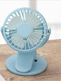 White portable clip fan with USB charging cable attached to stroller frame