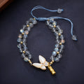 Grey moonstone butterfly charm on a handwoven cord bracelet for women.