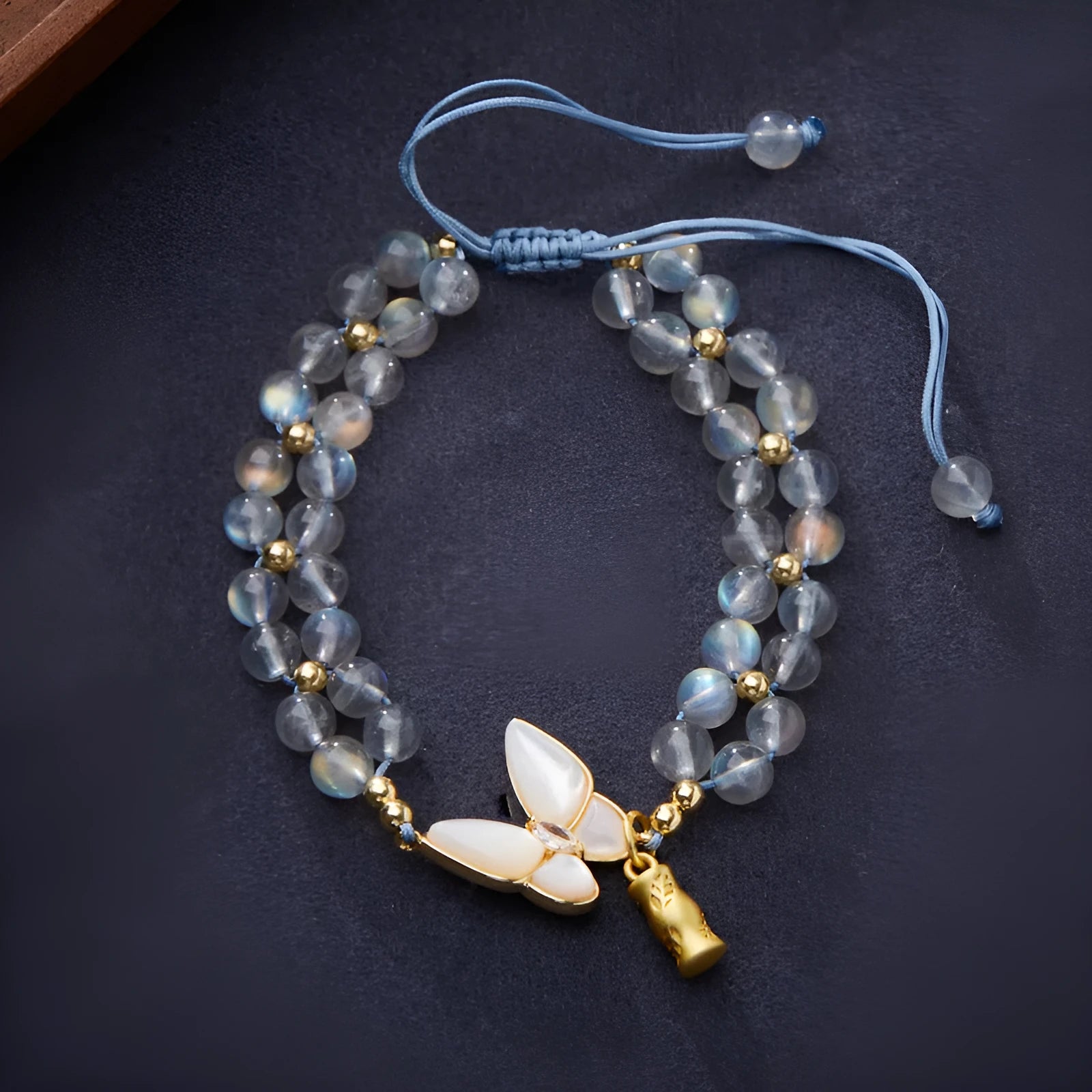 Grey moonstone butterfly charm on a handwoven cord bracelet for women.