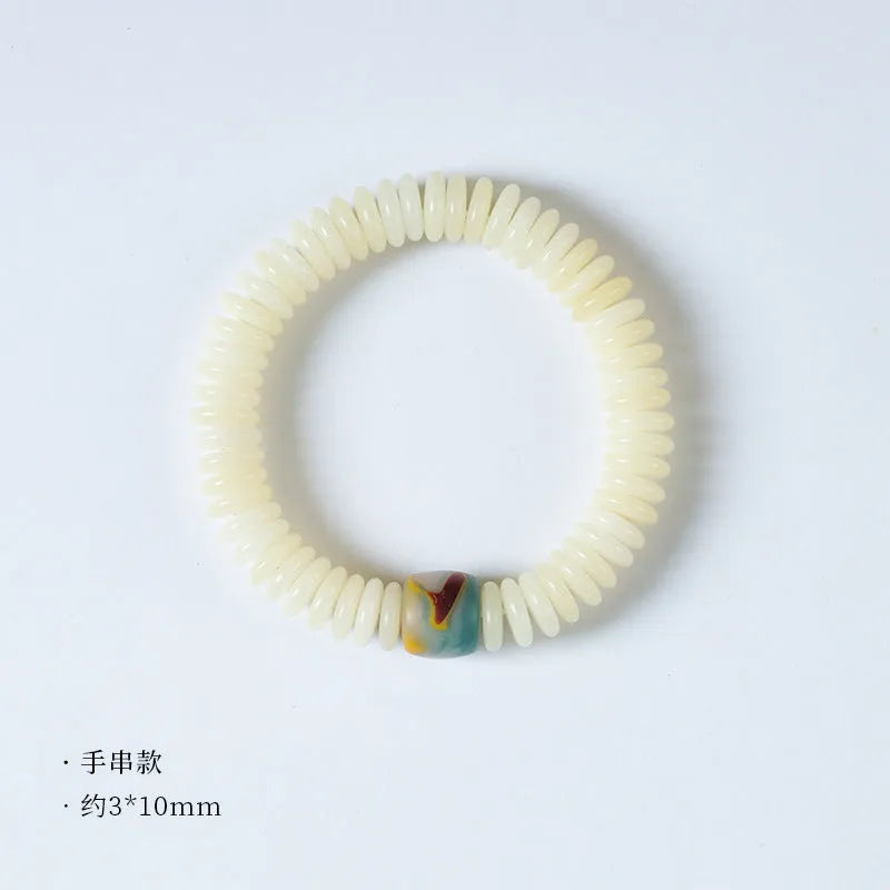 Close-up of a White Bodhi seed bracelet showing its 3x10mm beads and string.
